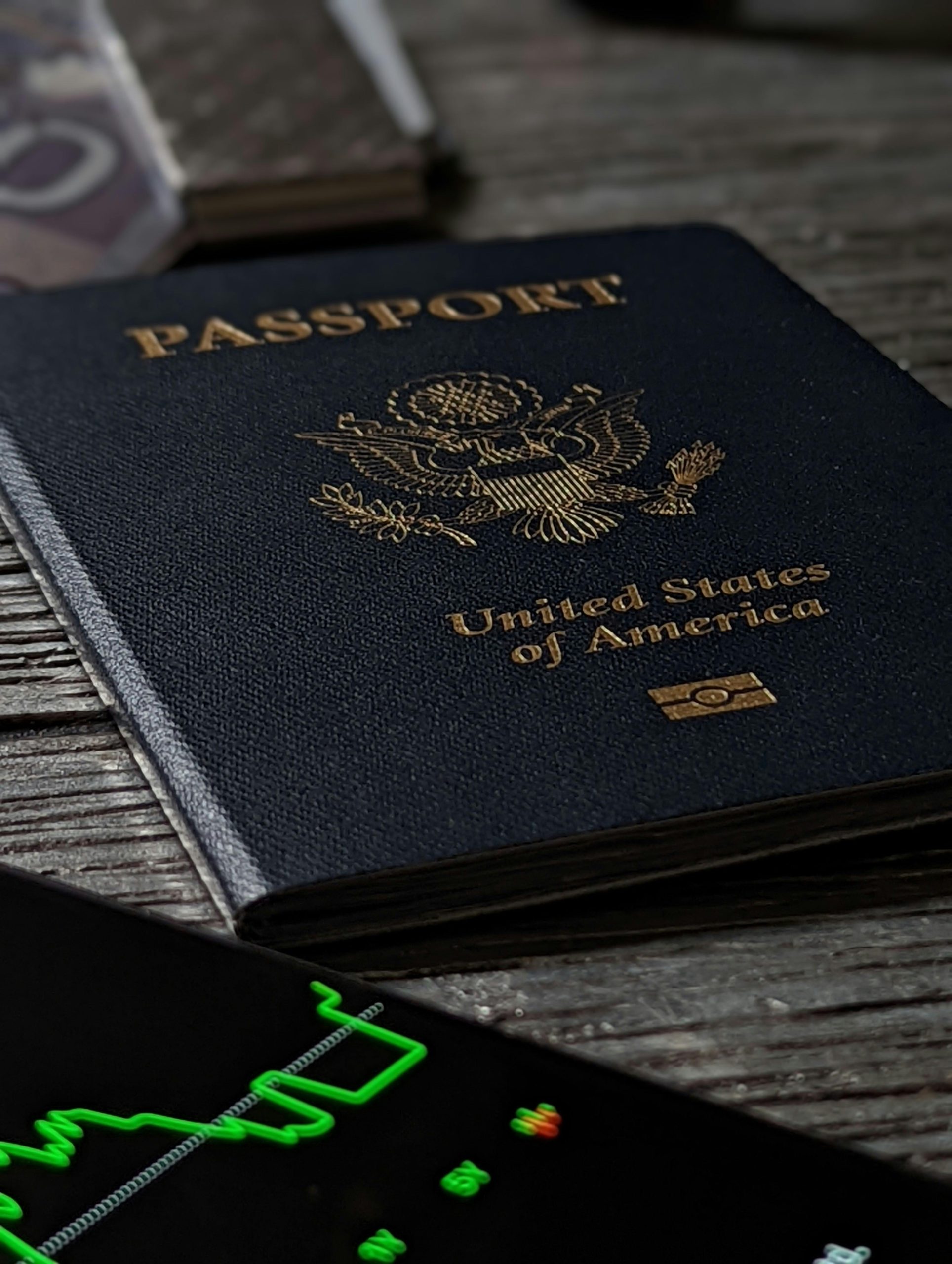 Close-up of a United States passport on a rustic wooden table with a smartphone nearby.